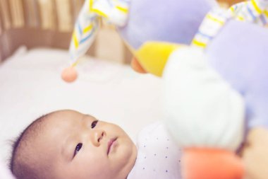 Renkli oyuncak jimnastik oynayan sevimli yeni doğan bebek 