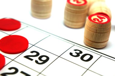 Piyango oyunu, tahta loto fıçıları, kesesi, cipsler ve beyaz arka planda loto oynamak için bir kart. Tahta oyunu bingosu.