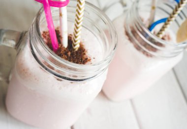 Milkshake, çikolata kırıntısı muz dilimi ve pipet, sağlıklı ve lezzetli.