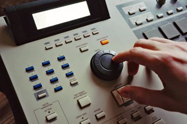 Adam ritim makinesinde müzik yapıyor, elleri midi klavyesinde, hip hop yapımcısı