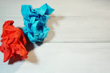 Kırmızı ve maviyle buruşmuş kağıtlar beyaz bir masada, arka plan için ve yazıyı sağmak için.,