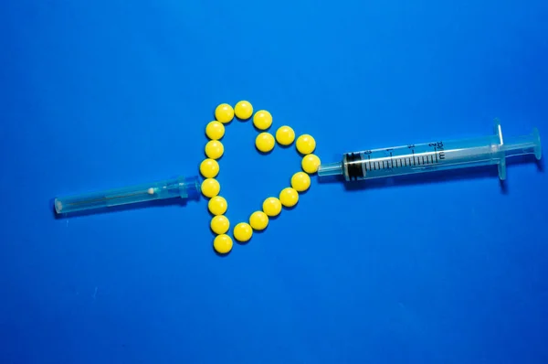 Желтые Таблетки Выкладываются Форме Сердца Стрела Пронзают Шприц Здоровье Помощью — стоковое фото