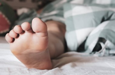 Bir kızın bacakları battaniyenin üzerinde, hafta sonu sabahı, uyanmak için tembellik.,