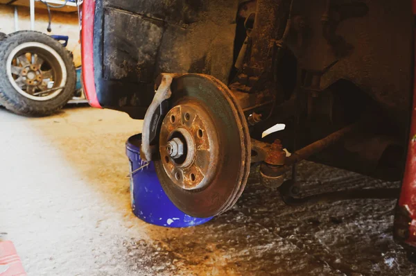 car on a jack without a wheel, brake pad replacement, car repair