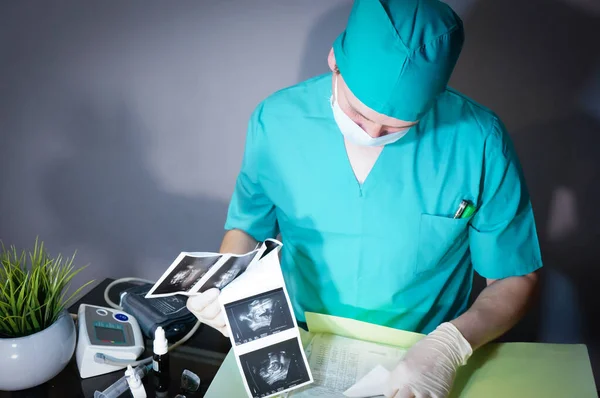Male Doctor Examines Ultrasound Pictures — Stock Photo, Image