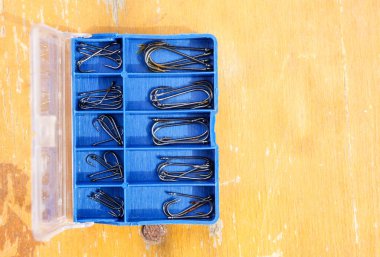 Bir kutuda farklı boyutlarda olta kancaları, olta takımı.