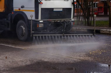 Coronavirus hastalığı COVID-19 salgınına karşı kapsamlı bir sokak dezenfeksiyonu ve dezenfekte. kamyonet şehirde yolları yıkıyor.