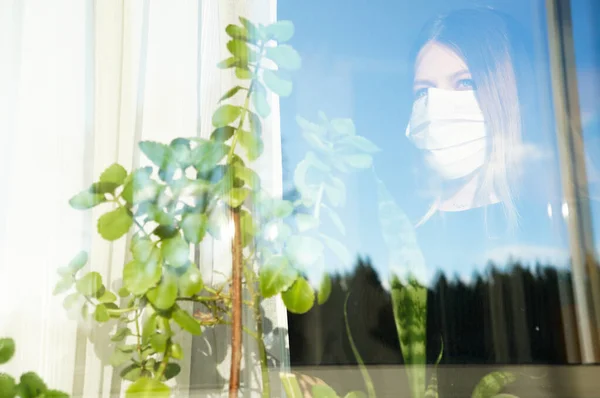 医療マスクの妊婦は 時間の自己分離で窓の外を見てフラッシュCovid — ストック写真