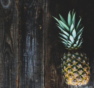 Ahşap zemin üzerinde taze olgun ananas ve metnin için yer var..