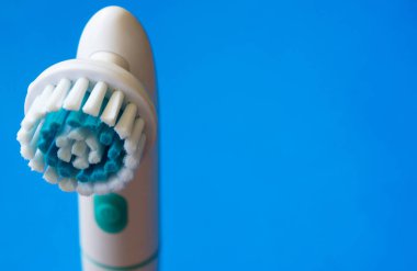 Mavi arkaplandaki makyajı temizlemek için özel bir fırça. Deri bakımı konsepti. Yüksek teknoloji güzelliği.