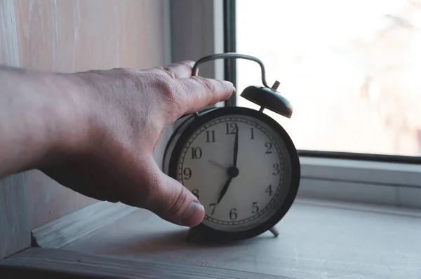 男人的手打开早上7点起床的闹钟 这就是工作日的概念 — 图库照片