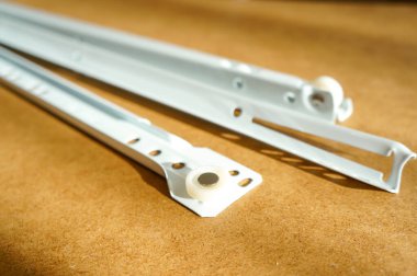 Ahşap arka planda beyaz şifonyer rayları