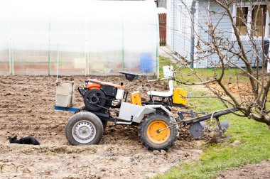Tarım, traktör, tarım mevsiminin başında tarımsal çalışmaların bir parçası olarak bir toprak ekicisiyle toprağı hazırlıyor.
