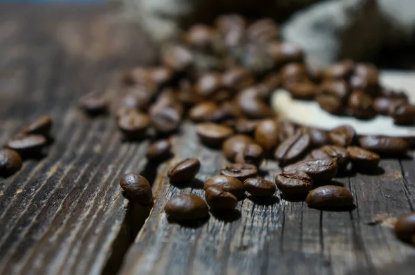 coffee beans from a bag scattered on a wooden table