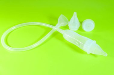 Tıp ve çocuk hijyeni kavramı. Açık yeşil arka planda çocuk burun aspiratörü..