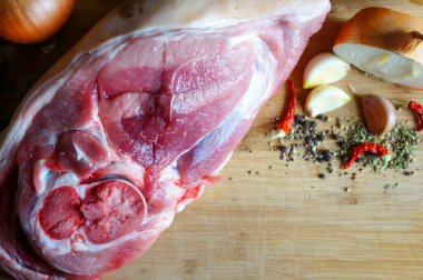  Baharat ve baharatla ahşap bir tahtanın üzerinde büyük taze bir parça domuz eti. Metinleriniz için bir yer, üst görünüm