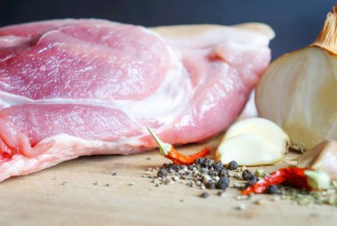  Baharat ve baharatla ahşap bir tahtanın üzerinde büyük taze bir parça domuz eti..