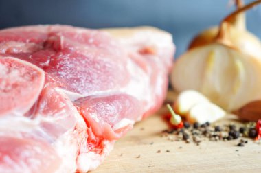  Baharat ve baharatla ahşap bir tahtanın üzerinde büyük taze bir parça domuz eti..