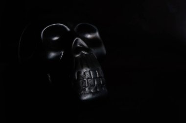 Siyah arkaplandaki insan kafatasının kopyası. Metnin için yer var.