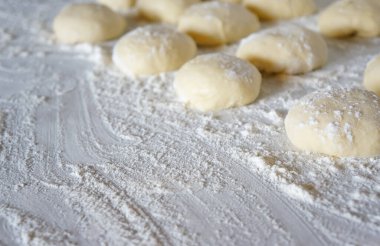 Beyaz bir masada un ve lahana ve patatesli turtalar için hamur.