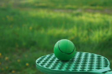 Beyzbol topuyla badminton, metinleriniz için çimenlerin üzerinde raketler, eğlence konsepti ve kırsalda doğa üzerine spor oyunları.