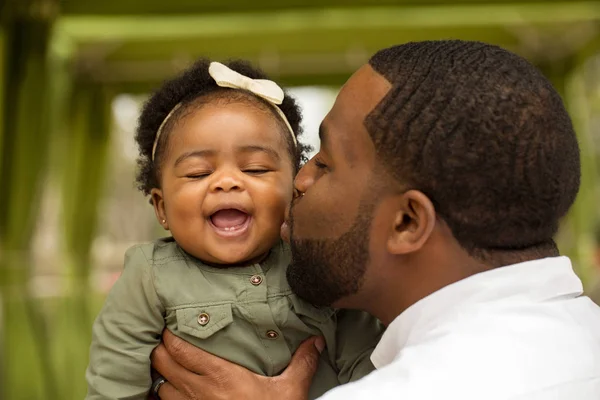 Padre afroamericano sosteniendo a su hija . —  Fotos de Stock