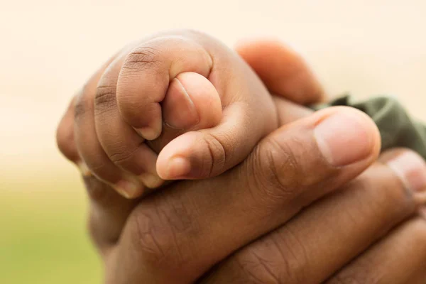 Padre afroamericano sosteniendo a sus hijas de la mano . —  Fotos de Stock