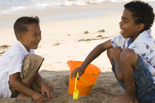 Young kids playing in the sand at the beach. — Stock Photo, Image