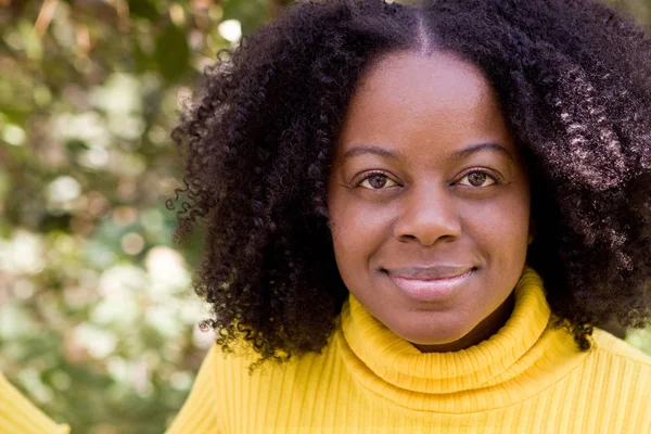 Confident African American woman outside in a garden. — Stock Photo, Image