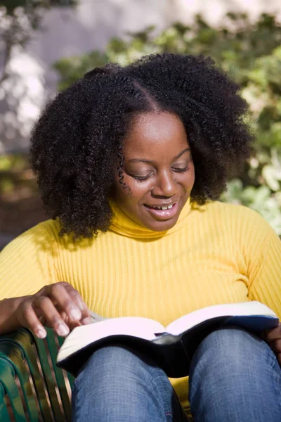 Mujer afroamericana leyendo afuera en la naturaleza . —  Fotos de Stock