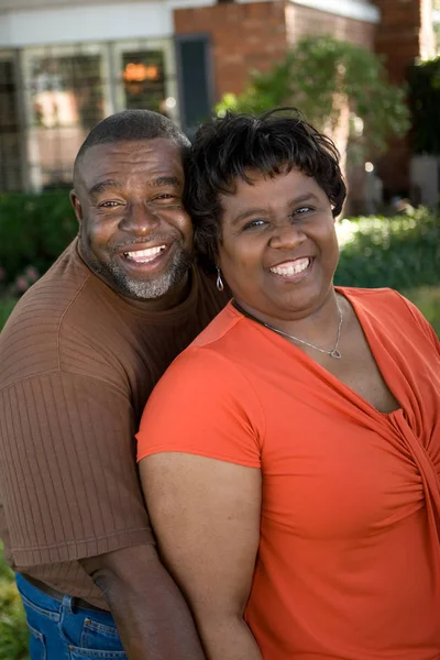 Mature African American couple laughing and hugging. — Stock Photo, Image