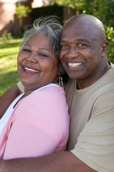 Mature African American couple laughing and hugging. — Stock Photo, Image