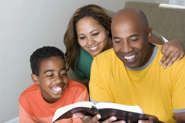 Família multicultural afro-americana leitura A Bíblia . — Fotografia de Stock