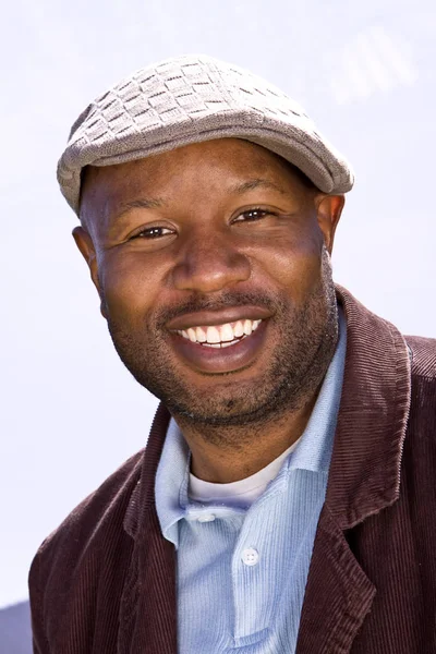 Ευτυχισμένος αφρικανική αμερικανική άνθρωπος, χαμογελαστός, φορώντας ένα καπέλο. — Φωτογραφία Αρχείου
