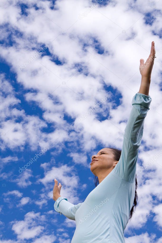 Happy woman standing outside with open arms.