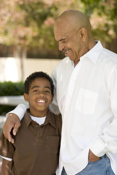 Happy African American grandfather and grandson laughing.