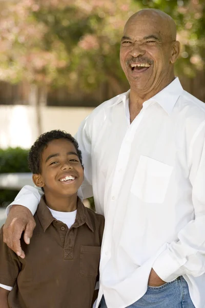 Happy African American grandfather and grandson laughing.
