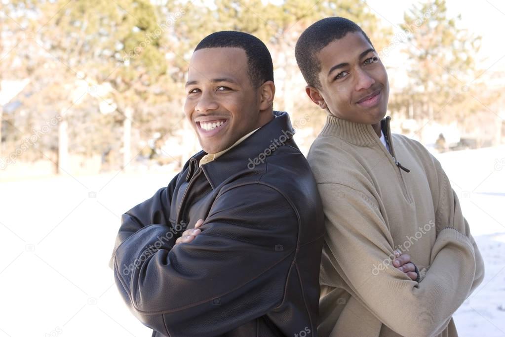 Portrait of African American teenage brothers smiling.