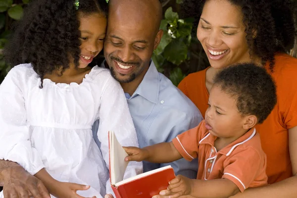 Amare i genitori afroamericani che leggono con i loro figli . — Foto Stock