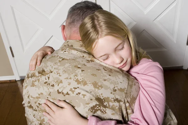 Happy young girl hugging her father in uniform — Stock Photo, Image