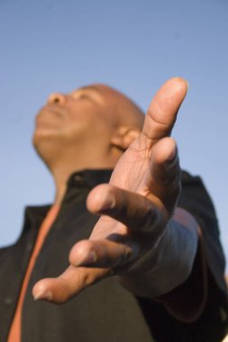 African American man with open arms in deep worship. clipart