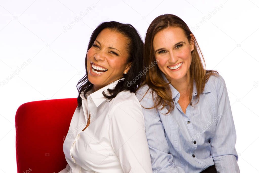 Happy women sitting in a red chair.