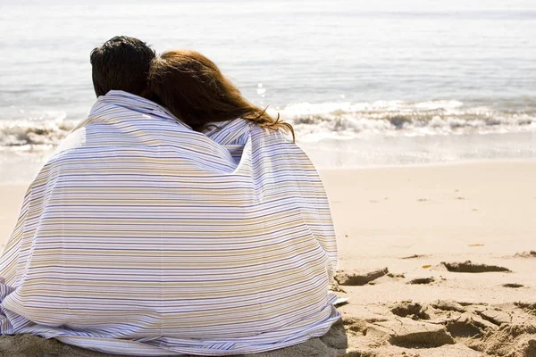 Beautiful Hispanic couple wrapped in a blanket. — Stock Photo, Image