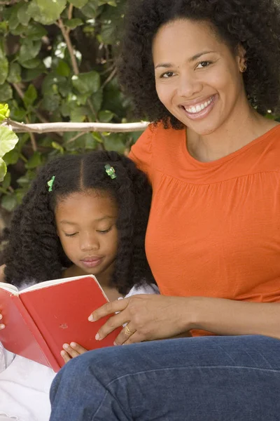 Madre afroamericana y su hija leyendo . —  Fotos de Stock