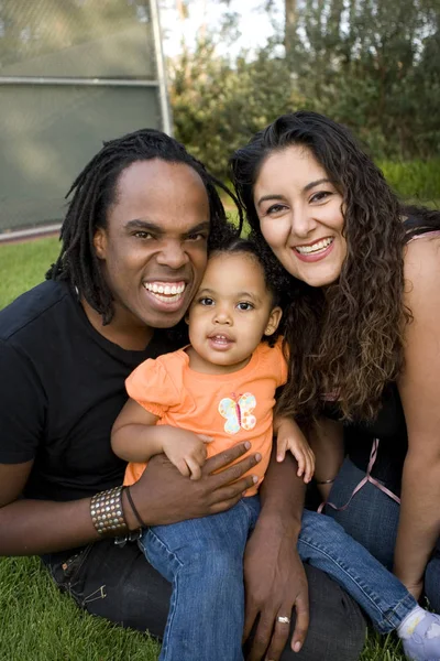 Feliz familia birracial sonriendo en un parque . — Foto de Stock