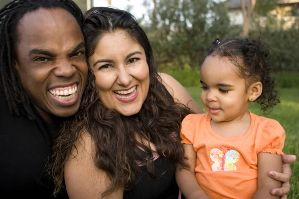Feliz familia birracial sonriendo en un parque . — Foto de Stock