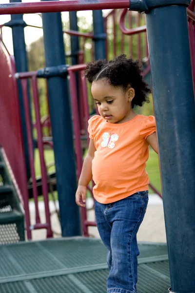 Pequena menina biracial jogando no parque . — Fotografia de Stock