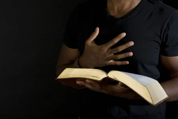 Man reading a bible isolated on black. — Stock Photo, Image