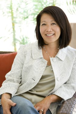 Güzel olgun kendine güvenen Asyalı kadın gülümseyerek