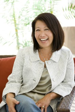 Güzel olgun kendine güvenen Asyalı kadın gülümseyerek